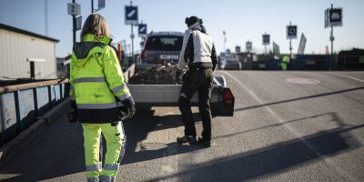 Personal på återvinningscentralen hjälper kund som lastar av sin kärra