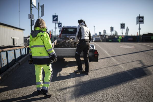 Personal på återvinningscentralen hjälper kund som lastar av sin kärra